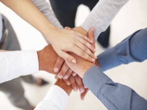 Group of business people making a pile of hands