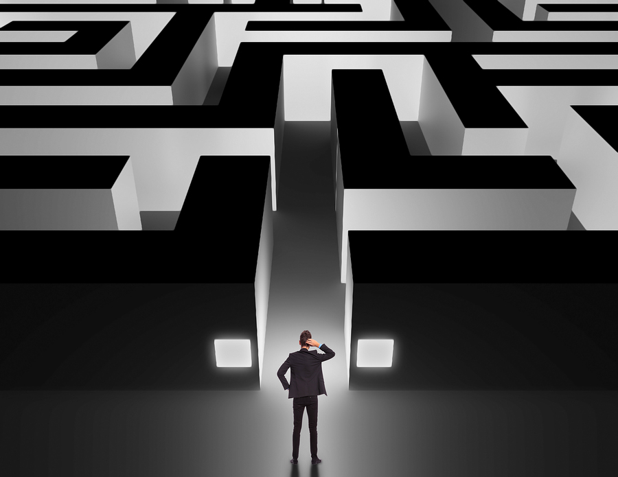 Business man in front of a huge maze